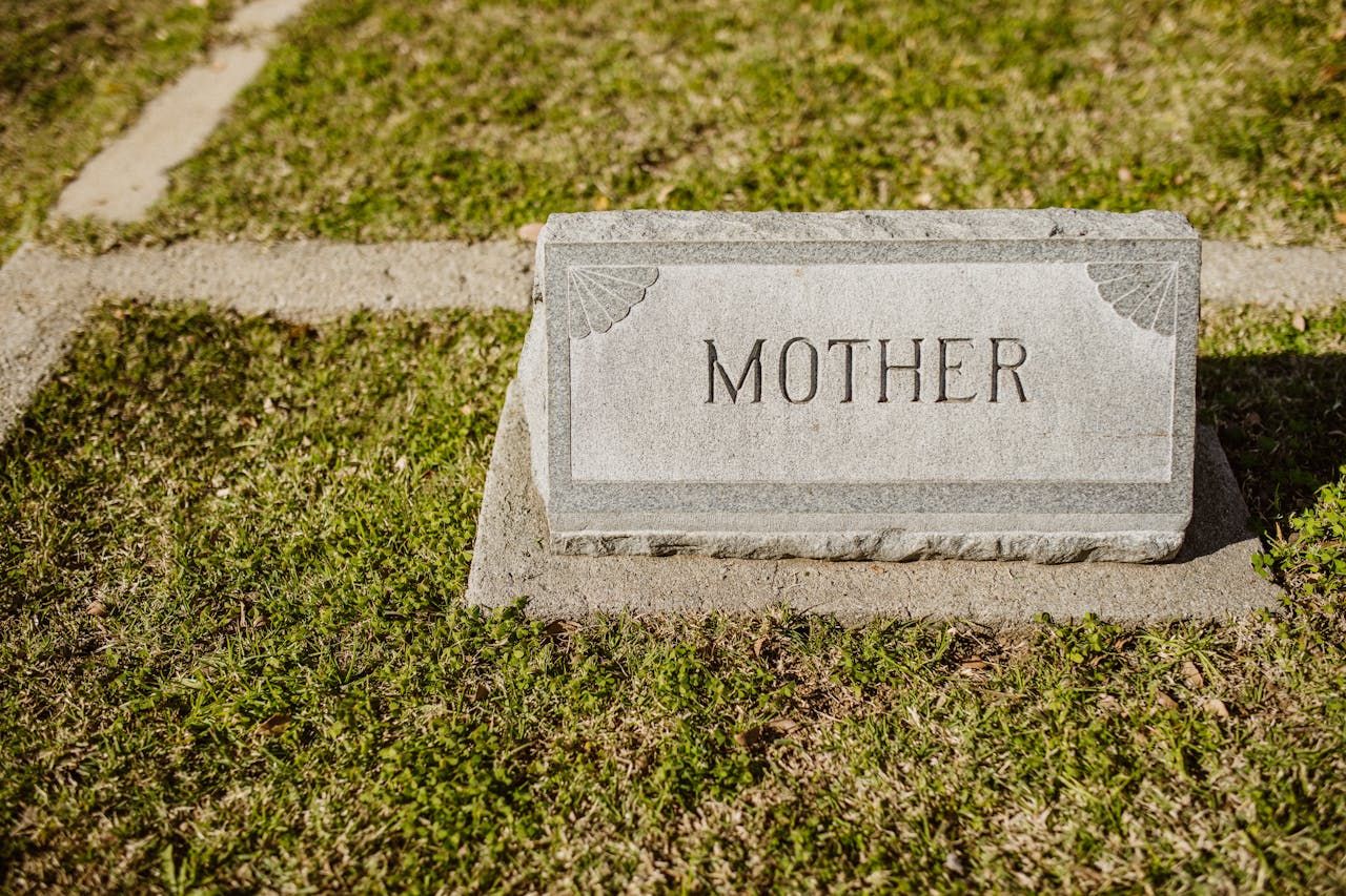 Gravestone in cemetery engraved with the word Mother on grass.